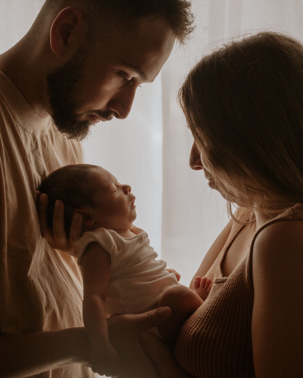 Deux parents tiennent tendrement leur nouveau-né dans leurs bras
